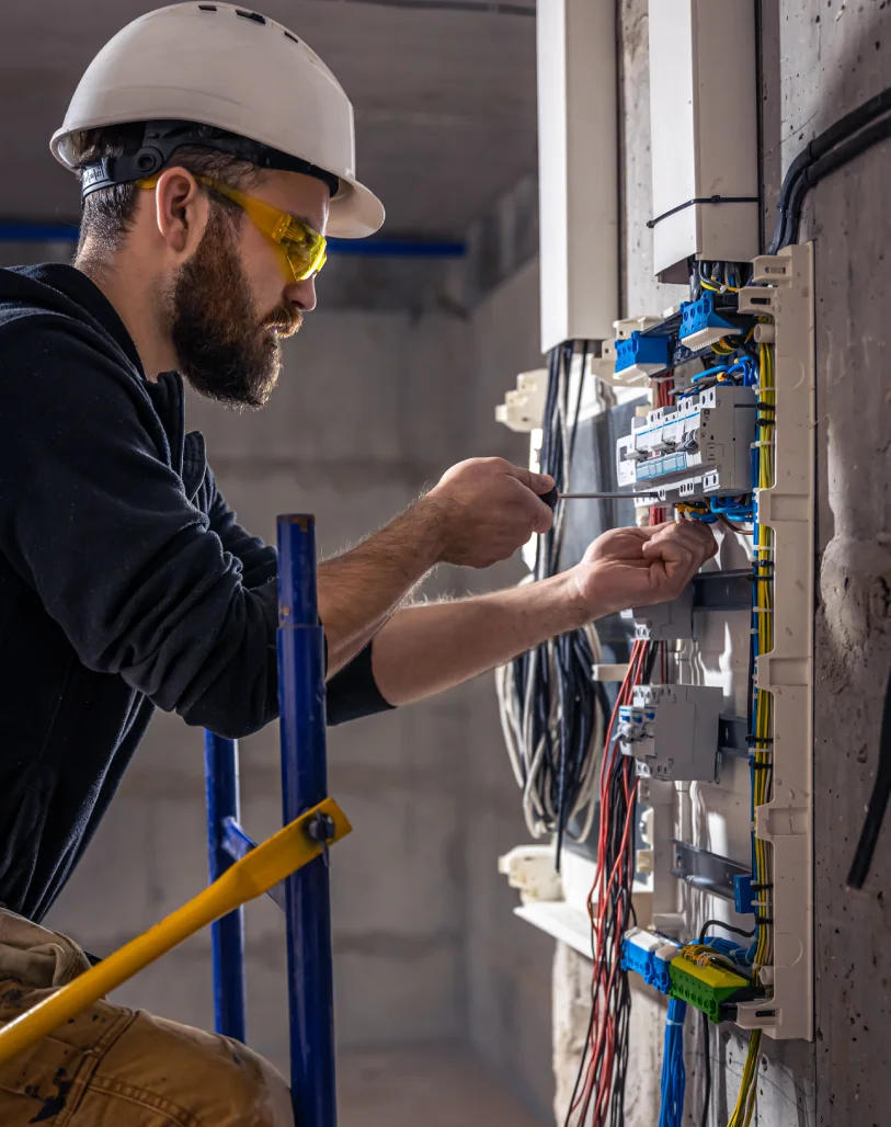 un electricista masculino trabaja en una centralita con un cable de conexion electrica